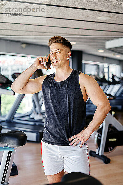 Männlicher Athlet telefoniert im Fitnessstudio