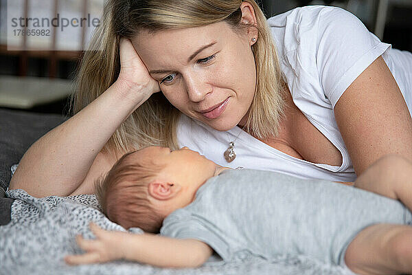 Die junge Mutter blickt ihr Neugeborenes liebevoll an