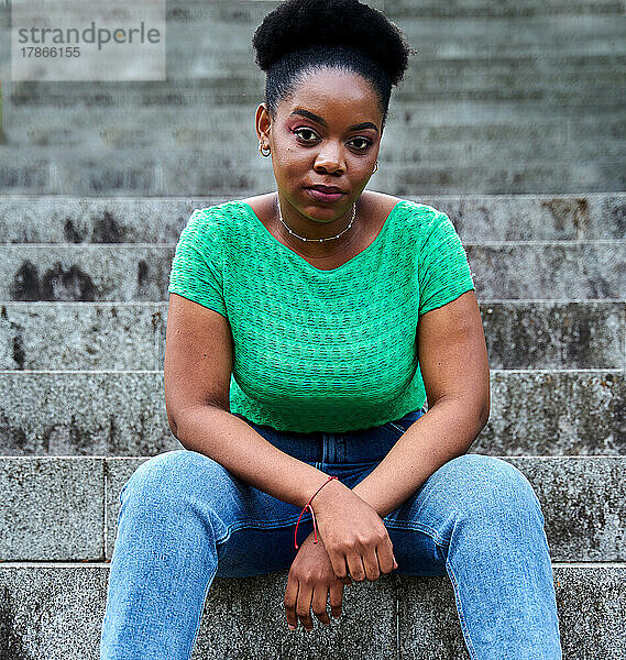 Afroamerikanische Frau sitzt auf einer Treppe