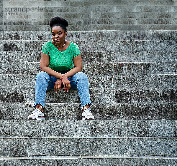 afroamerikanische Frau sitzt lächelnd auf der Treppe