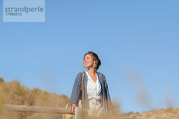 Junge Frau im Urlaub spaziert glücklich auf dem Feld im Freien