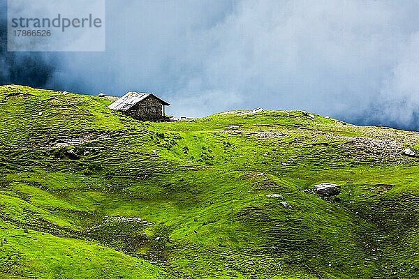 Gelassenheit heitere einsame Landschaft Hintergrund Konzept  Haus in den Hügeln in mountins auf alpine Wiese in Wolken