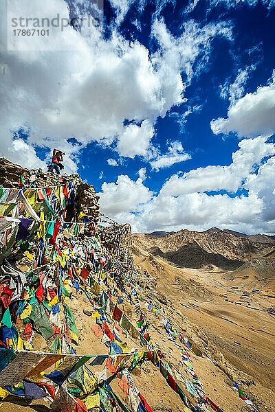 Reisefotograf fotografiert in den Bergen des Himalaya auf einer Klippe mit buddhistischen Gebetsfahnen. Leh  Ladakh  Jammu und Kaschmir  Indien  Asien