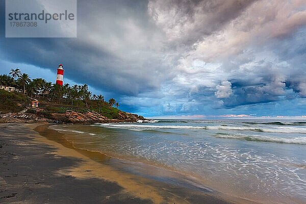 Aufkommender Sturm am Strand und der Leuchtturm von Kovalam (Vizhinjam) bei stürmischem Sonnenuntergang. Kerala  Indien  Asien