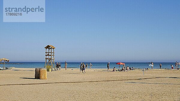 Touristen laufen am Strand  Wachturm  blauer wolkenloser Himmel  Sandstrand  Strand von Elafonissi  Südwest-Kreta  Insel Kreta  Griechische Inseln  Griechenland  Europa