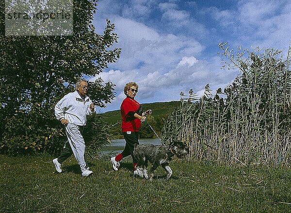Älteres Paar beim Laufen mit Hund