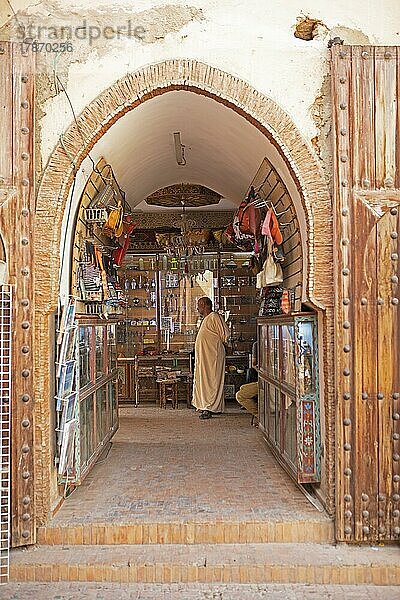 Marokkanischer Mann im Djellaba oder traditionellen Kapuzenmantel steht in einem Laden in der Altstadt  Meknès  Marokko  Afrika