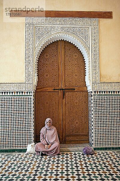 Marokkanische Frau vor einem traditionellen Holztor  Moulay Ismael Mausoleum  Meknès  Marokko  Afrika