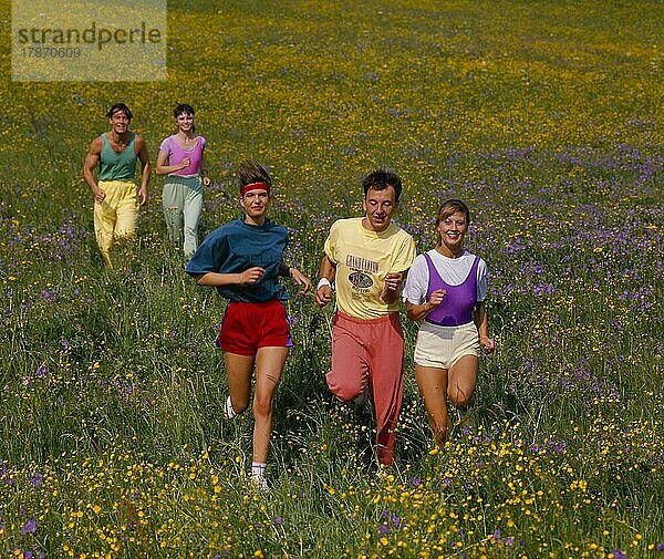Junge Leute joggen durch Blumenwiese