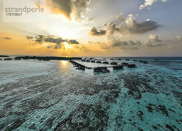 Malediven  Nord-Male-Atoll  Lankanfushi  Luftaufnahme des Indischen Ozeans bei Sonnenuntergang mit Ferienbungalows im Hintergrund