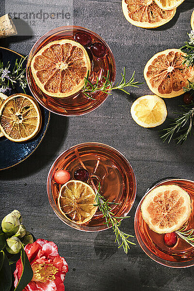 Cranberry-Champagner-Cocktails  garniert mit Orange und Rosmarin
