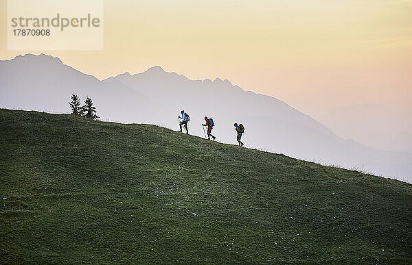 Wanderer mit Wanderstöcken auf dem Berg bei Sonnenaufgang  Mutters  Tirol  Österreich