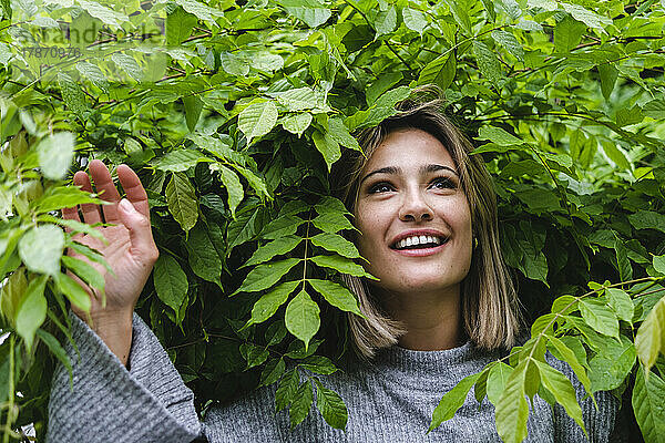 Glückliche Frau inmitten grüner Blätter