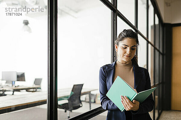 Junge Geschäftsfrau mit Tagebuch im Büro