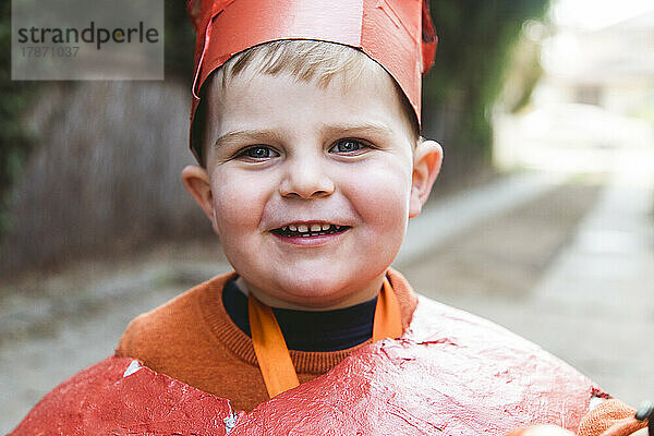 Fröhlicher Junge trägt selbstgemachtes Kürbis-Halloween-Kostüm
