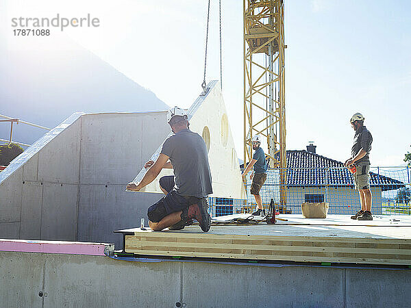 Bauarbeiter installieren Dach an sonnigem Tag