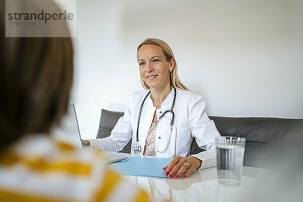 Female doctor smiling at boy in medical practice