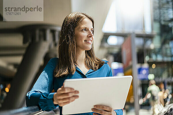 Nachdenkliche Geschäftsfrau mit Tablet-PC im Büro
