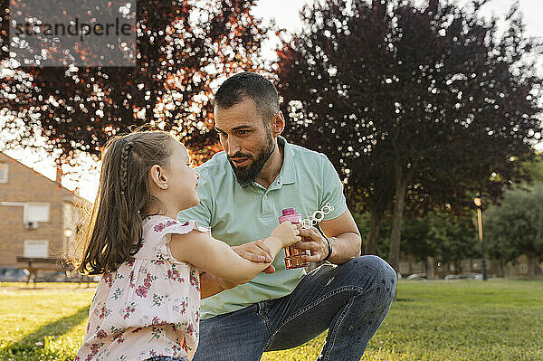 Vater spricht mit Tochter im Park