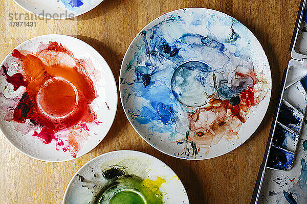 Watercolors in plates on table at home