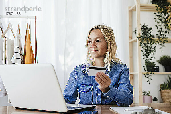 Geschäftsfrau tätigt Online-Einkäufe per Kreditkarte im Heimbüro