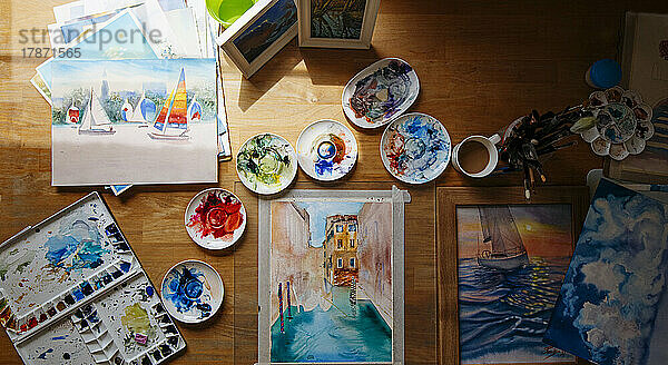Aquarellmalerei und unordentliche Farbpaletten auf dem Tisch