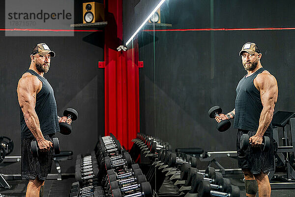 Bodybuilder trainiert mit Hanteln im Fitnessstudio