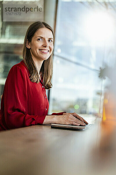 Smiling businesswoman at desk in office