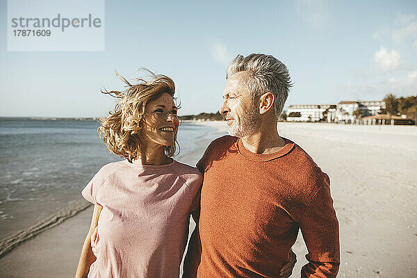 Glückliches älteres Paar am Strand an einem sonnigen Tag