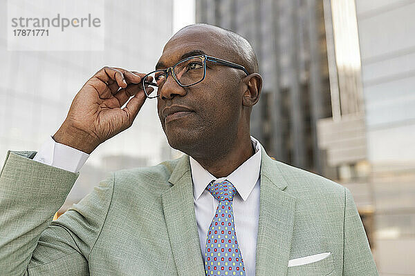 Reifer Geschäftsmann mit Brille im Finanzviertel