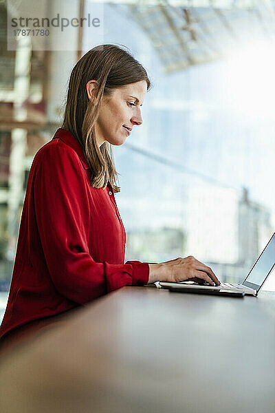 Geschäftsfrau arbeitet am Arbeitsplatz am Laptop