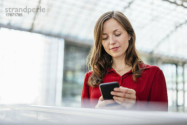 Frau mit braunem Haar benutzt Smartphone