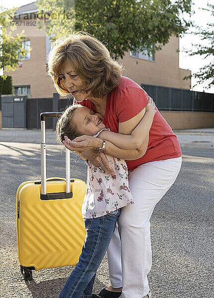 Nettes Mädchen umarmt Großmutter  die auf der Straße steht