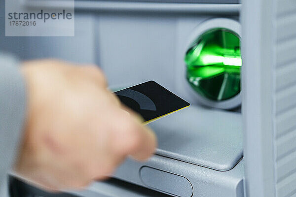 Geschäftsmann benutzt Kreditkarte am Geldautomaten