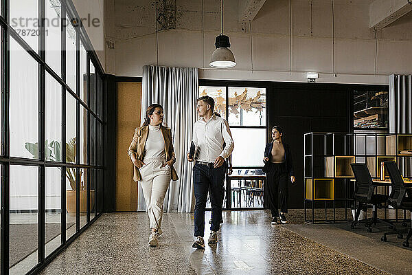 Geschäftskollegen gehen gemeinsam im modernen Büro spazieren