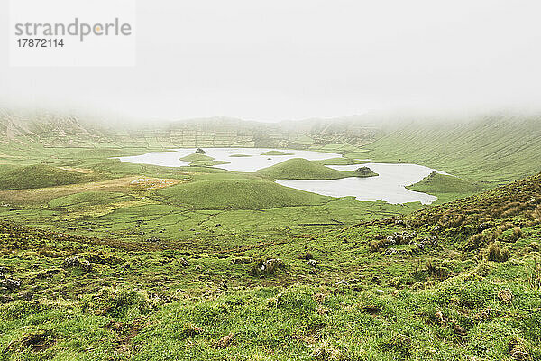 Idyllic view of lake amidst green landscape on foggy day at Corvo Island  Azores  Portugal