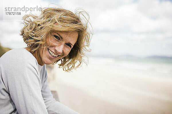 Glückliche blonde Frau genießt den Strand
