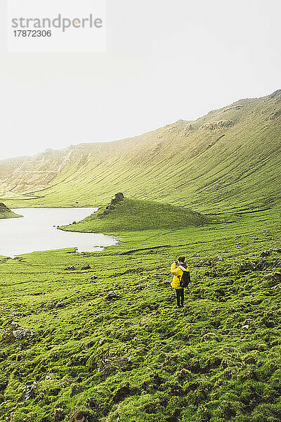 Young woman standing on green landscape at Corvo Island  Azores  Portugal