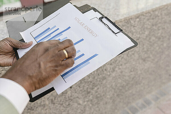 Hands of businessman examining graph