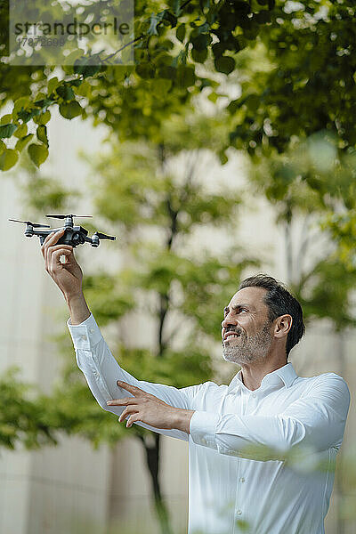 Reifer Geschäftsmann analysiert Drohne