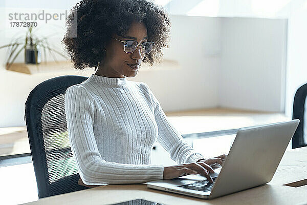 Junge Geschäftsfrau arbeitet im Büro am Laptop