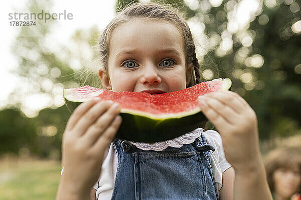 Nettes Mädchen  das im Park Wassermelone isst