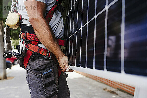 Techniker trägt schweres Solarpanel