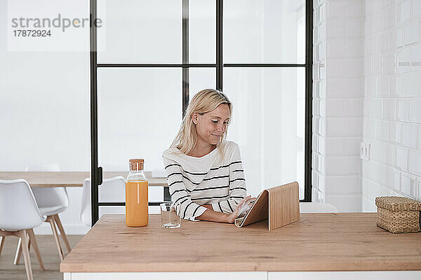 Junge Frau benutzt Tablet-PC auf dem heimischen Tisch