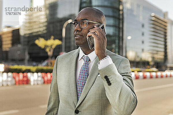 Geschäftsmann telefoniert auf der Straße im Finanzviertel mit dem Mobiltelefon