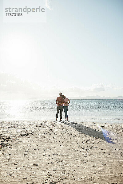 Älteres Paar steht an einem sonnigen Tag am Strand