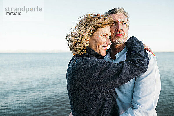 Lächelnder reifer Mann und Frau genießen den Urlaub am Strand