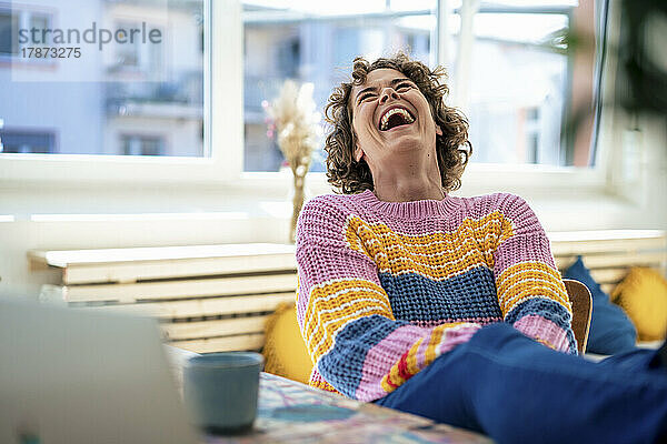 Cheerful woman laughing at home