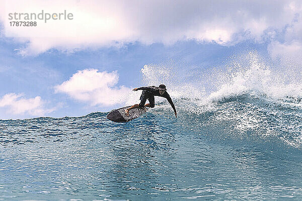 Mann surft im Urlaub im Meer