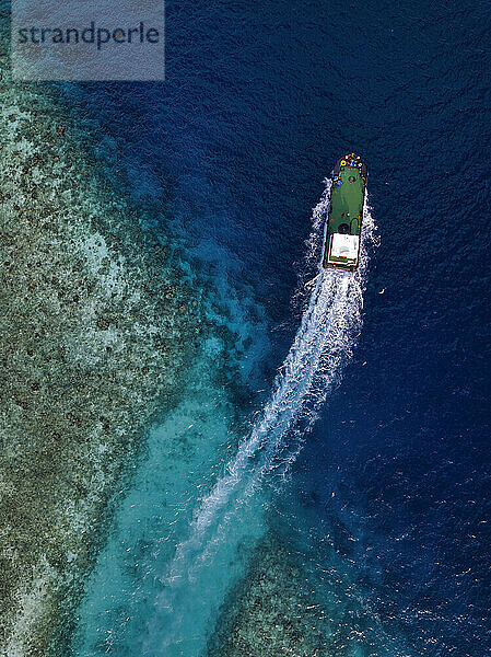 Maldives  Kaafu Atoll  Himmafushi  Aerial view of motorboat sailing across coastal water